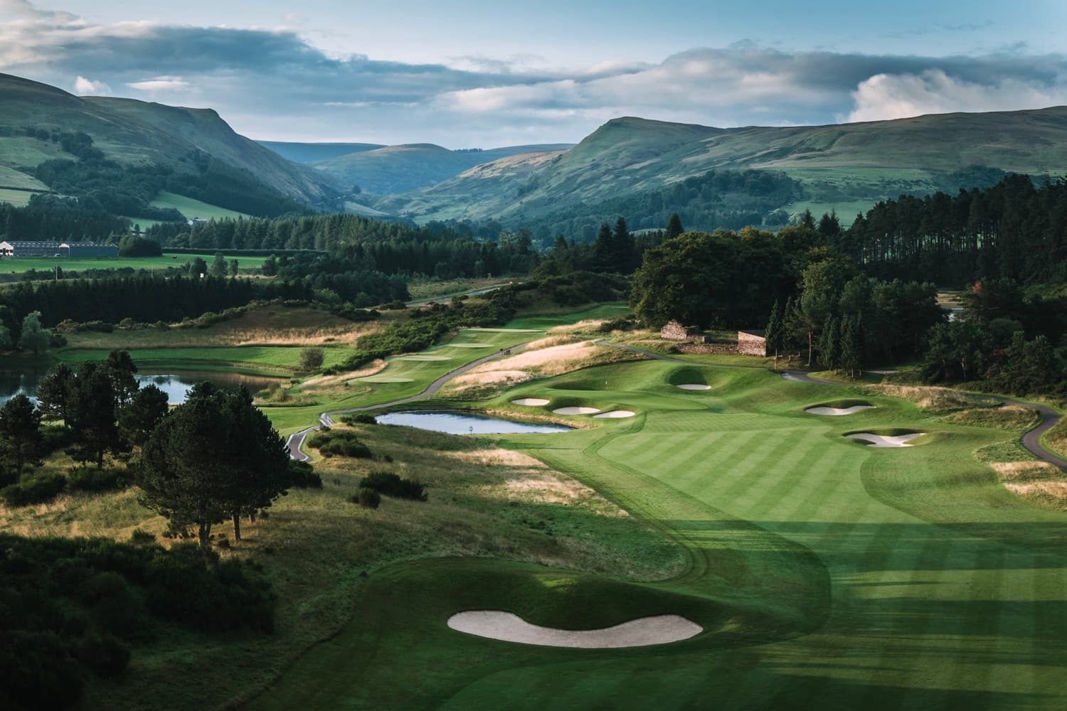 Aerial view of a parkland championship course beneath the hills